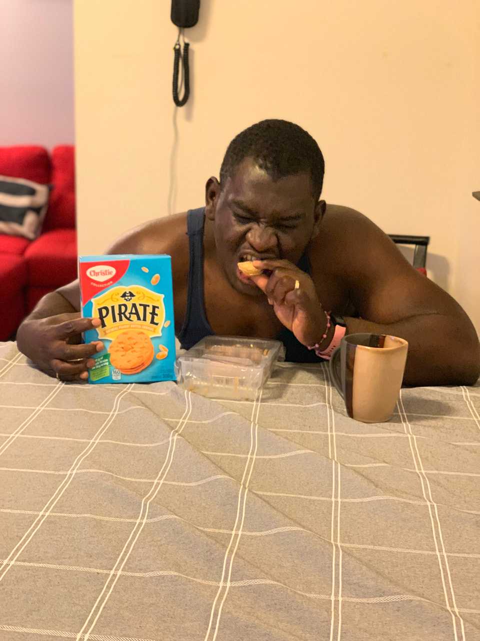 Aristote qui avale un biscuit en touchant le carton des biscuits pirates avec sa main droite