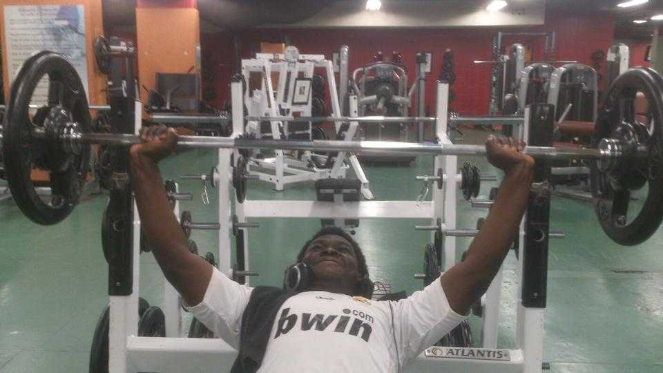 A black male lifting weight at the gym