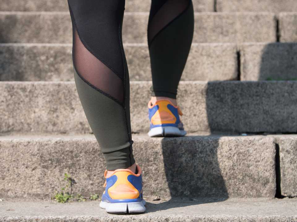 Les pieds d’une jeune femme montant des escaliers